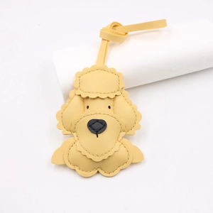 Yellow leather teddy dog bag charm with litchi grain texture and knotted lanyard strap