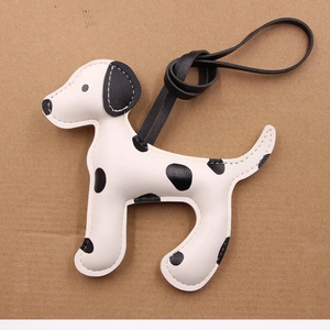 Détail d'un pendentif chien dalmatien en cuir artisanal avec coutures contrastées