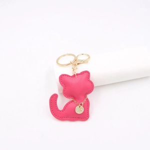 Macro detail of rose pink leather cat keychain with gold hardware and fine stitching