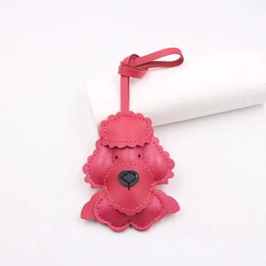 Detail of a pink leather puppy bag charm with wavy stitching and heart-shaped nose