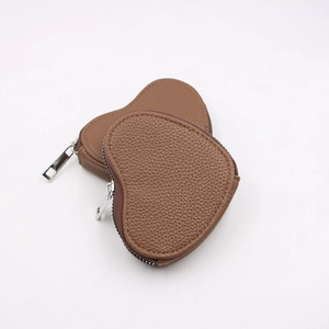 Close-up of brown heart-shaped leather coin purses with litchi texture and silver zipper