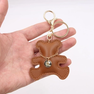 Detailed view of a brown leather bear keychain with hand-stitched edges and gold lobster clasp