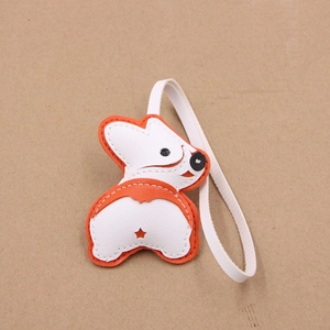Détail d'un bijou de sac Corgi en cuir avec coutures fines blanches et orange