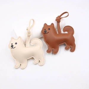 Cute dog-shaped leather bag charms in cream white and brown with fine stitching detail
