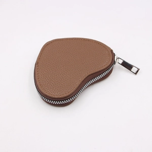 Close-up of heart-shaped brown pebble leather coin purse with silver metal zipper detail