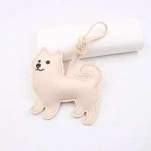 Close-up of beige leather dog charm with detailed stitching and soft texture