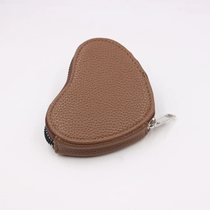 Detail of heart-shaped mini leather coin purse with silver zipper and lychee texture