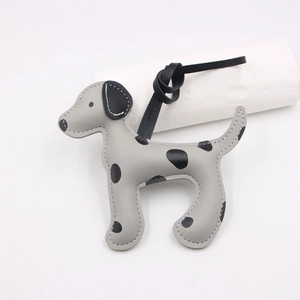 Détail d'un bijou de sac en cuir en forme de dalmatien avec motif à pois gris
