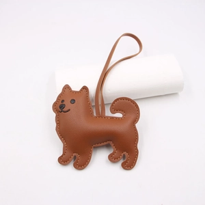 Detailed view of a brown leather puppy bag charm featuring exquisite white stitching craft