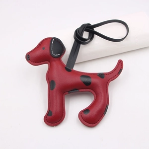 Vue détaillée des coutures artisanales sur le pendentif de sac chiot en cuir rouge tacheté