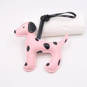 Détail d'un bijou de sac chien dalmatien en cuir rose avec taches noires et fines coutures