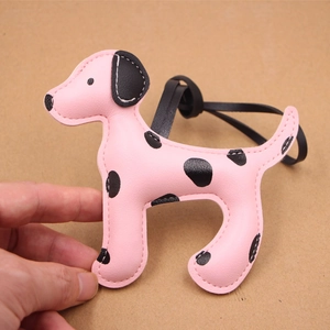 Gros plan détaillé d'un bijou de sac chien rose à pois en similicuir cousu avec cordon