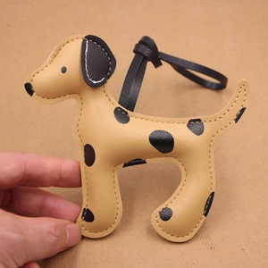 Vue détaillée du pendentif de sac en cuir motif dalmatien avec cordon en cuir tressé