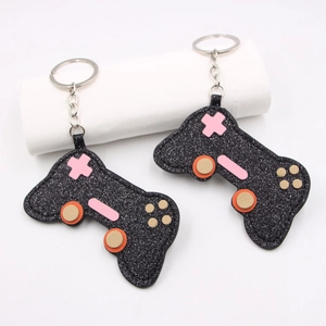 Sparkly black glitter game controller keychains with colorful buttons and silver rings
