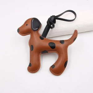 Détail du charm de sac en cuir motif chien tacheté avec des coutures à la main