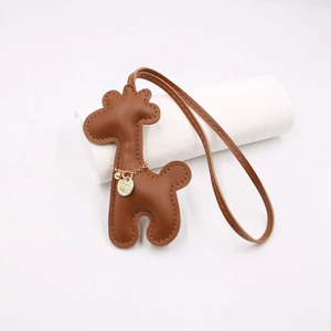 Handmade brown leather giraffe bag charm with elegant gold chain and refined stitching details