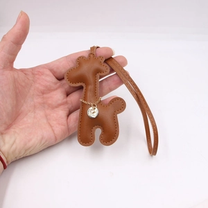 Detailed shot of brown leather giraffe pendant with hand-stitched seams and gold chain