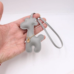 Handmade light gray leather giraffe bag charm with elegant gold chain and metal pendant