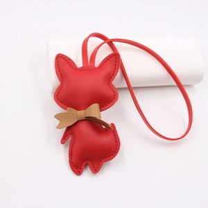 Close-up of red leather fox charm with brown bowtie and hand-stitched details