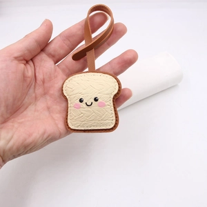 Handheld cute toast bread leather bag charm with a simple face and cream PU finish