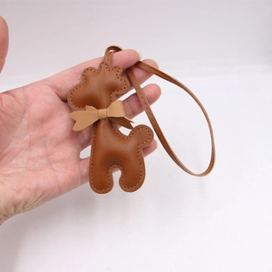Bijou de sac girafe en cuir marron avec nœud papillon et lanière sur fond gris