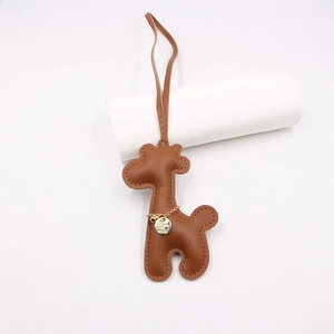 Brown leather giraffe bag charm and keychain with golden chain and fine stitching detail