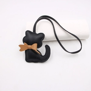 Cute black textured leather cat charm with a brown bow and long lanyard for bag accessories
