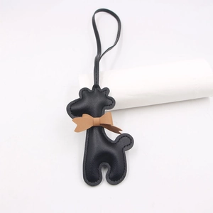 Détail d'un porte-clés girafe en cuir noir avec un nœud marron et une lanière longue