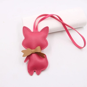 Detail of rose pink fox leather charm with bowknot and delicate stitching craft