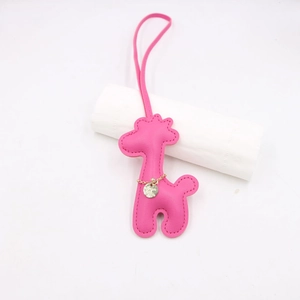 Detail of rose pink PU leather giraffe bag charm with neat stitching and gold chain