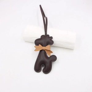Détail d'un bijou de sac chiot en cuir marron foncé avec nceud et coutures apparentes