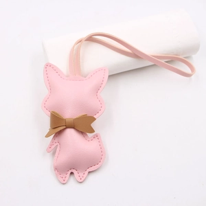 Close-up of pink leather fox charm with brown bowknot and visible stitching detail