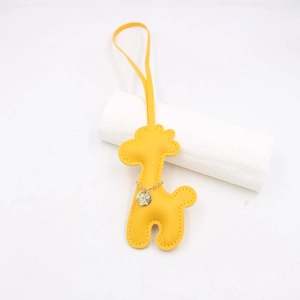Close-up of yellow leather giraffe bag charm with detailed stitching and gold chain