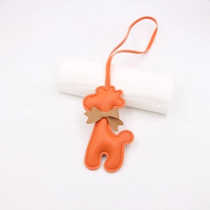 Détail du pendentif girafe en cuir synthétique orange avec un nœud marron