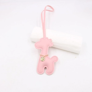 Detail of pink leather giraffe charm with handmade stitching and gold metal pendant