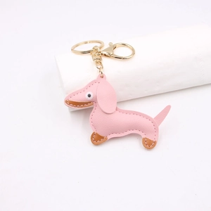 Close-up of pink leather dachshund keychain with golden hardware and detailed stitching
