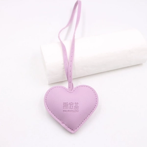 Lilac heart-shaped leather bag charm with stitched edges and logo embossing