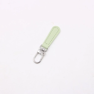 Detail view of light green leather zipper pull with silver metal lobster clasp