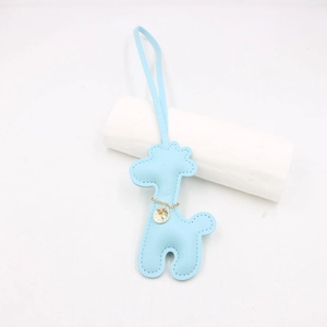 Detail of blue leather giraffe charm featuring gold chain and circular metal pendant