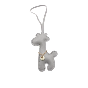Handmade grey leather giraffe bag charm with golden pendant and white stitching detail