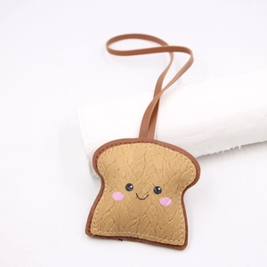 Ciondolo a forma di pane tostato in pelle marrone con viso sorridente per borse e zaini