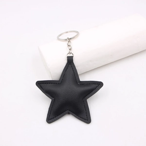 Detail view of a black leather star keychain with durable stitching and silver metal ring