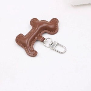 Porte-clés en cuir marron en forme de H avec fermoir rotatif en métal argenté sur blanc