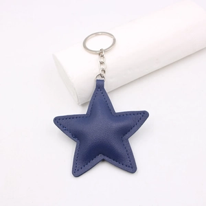 Navy blue star-shaped leather keychain with lychee texture and silver metal ring on white background
