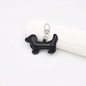 Détail d'un porte-clés teckel en cuir noir avec surpiqûres et mousqueton argenté métal