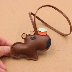 Détail du bijou de sac en cuir Capybara avec grain galet et couture à la main marron