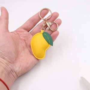 Porte-clés mangue en cuir jaune avec détail de feuille verte et mousqueton doré chic