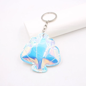Iridescent shell shaped leather keychain with metallic ring on a white display block