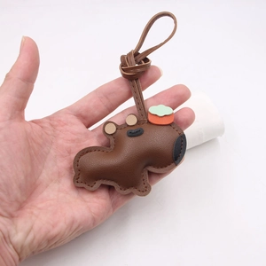 Gros plan détaillé d'un porte-clés capybara en cuir marron avec des coutures artisanales fines