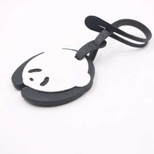Close-up of cute panda leather bag charm with lychee grain texture and long strap